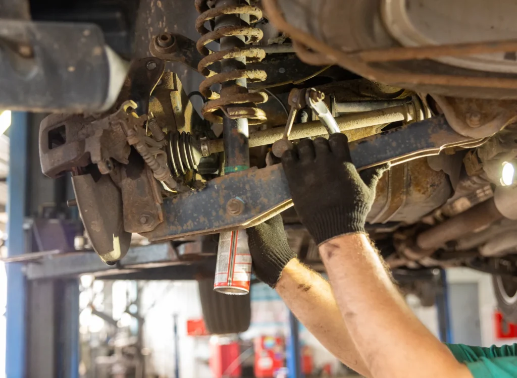 Mechanic repairing the driveline underneath a commercial truck