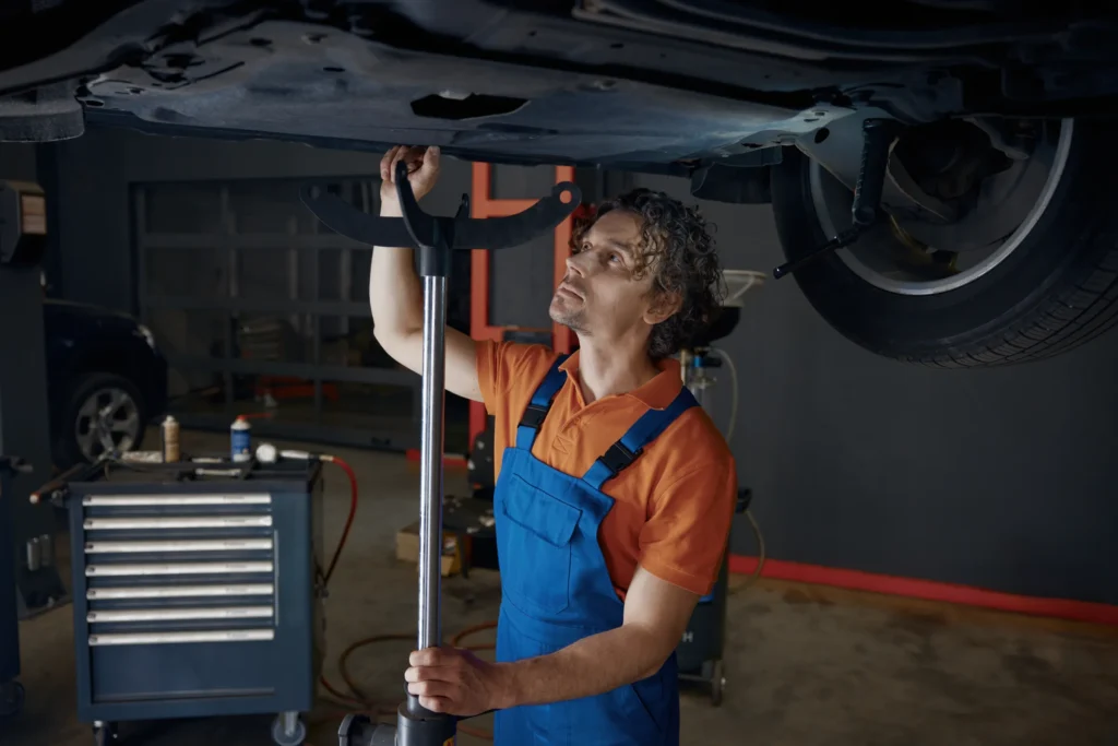 Mechanic performing preventive maintenance under a vehicle on a lift
