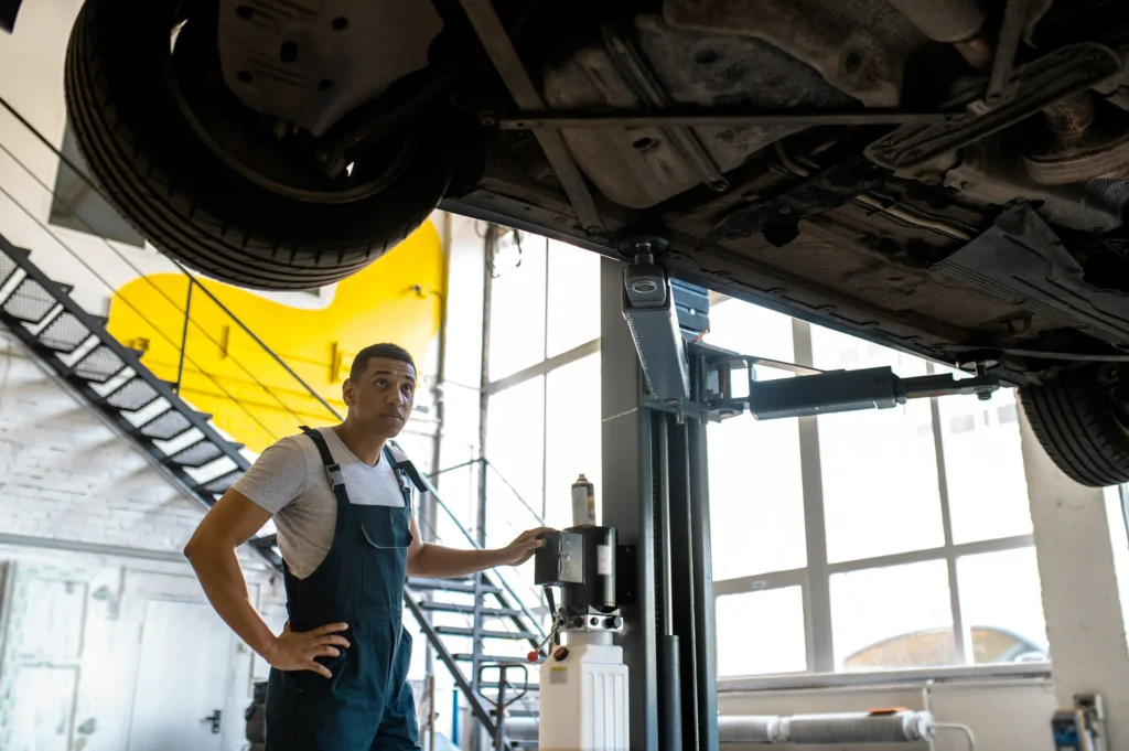 Technicians inspecting a vehicle on a lift during transmission diagnostics